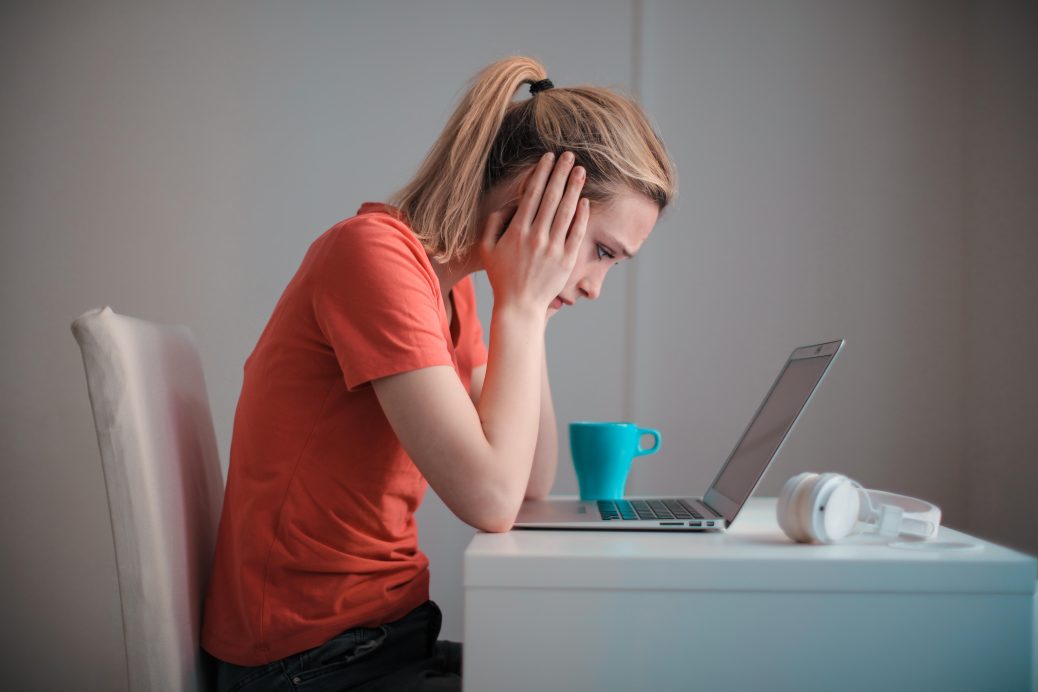 Woman unhappy at her desk and looking at her computer
